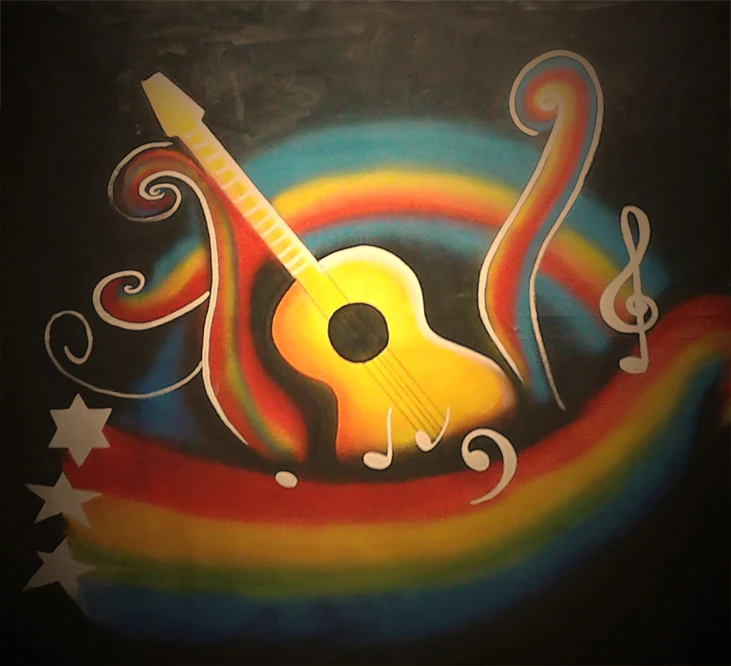 Painted acoustic guitar and musical notes in a colorful mural