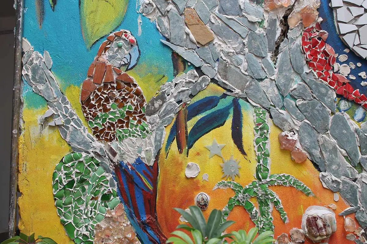 Mixed-media nature mural combining paint, mosaic and textured materials